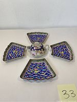 Overhead view of set showing four fan-shaped dishes in blue and gold with a floral creamer or teapot in center
