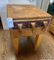 Front view showing butcher block top and three wooden elephant head hooks