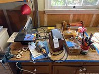 Overview of workbench showing Dremel saw/sander, Foredom motor, foot pedal and tool boxes with accessories