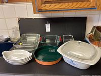 Photo of all items on countertop showing Pillivuyt baking dishes, Pyrex pans, Corning casserole with lid, and enameled clay pan