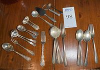Overview of all assorted sterling flatware pieces, servers and tools with lot tag visible