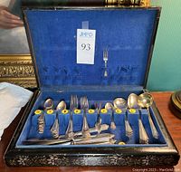 Open case displaying full set of flatware against blue felt
