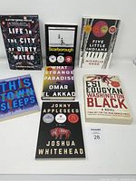 Front view of the seven books, showing cover designs and titles