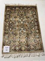 Full view of the beige and golden prayer rug showing entire pattern, fringe, and size.