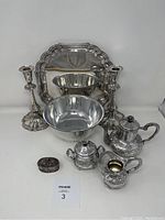 Image of entire lot showing two Victorian candlesticks, centerpiece bowl, rectangular tray, pierced box, and three-piece Turkish coffee set