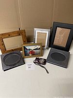 Full lot overview showing all frames, photo albums and camera on table.