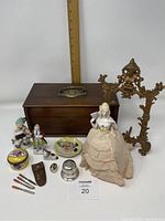 Full view of lot with Victorian walnut jewelry box, metal frame, porcelain doll, various small items and manicure set