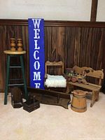 Photo showing the collection of Canadian country folk art decor including candle holders, stools, chairs, a wooden bucket, toy train and Welcome sign.