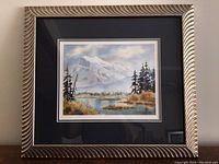 Frontal photo of framed watercolor art print "Mount Rundle" showing detailed mountain scene and textured frame.