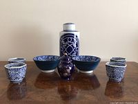 Front view of the 8 porcelain items laid out on a wooden surface