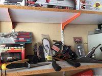 Shelf with assorted tools including handsaw, hand plane, mallet, pliers, mini air compressor, and pressure gauge