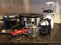 Overview photo of all small appliances on a kitchen counter, showing Crock-Pot, waffle maker, blender, handheld mixer, and glass kettle.
