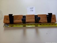 Front angle showing the maple wood base with three black folding hooks and a measuring tape beneath showing length near 17 inches