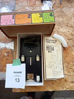 Bottle cutter kit with instruction booklet and packaging box showing steps to cut bottles.