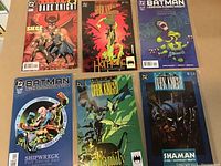 Six Batman comic books laid out in two rows of three, including titles The Dark Knight and Batman Legends, with colorful covers depicting Batman and other characters.