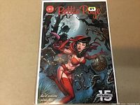 Front cover of Bettie Page #2 comic book showing artwork with Bettie Page in red outfit in a spooky forest scene with full moon in background.