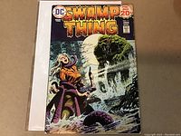 Front cover of Swamp Thing #11 comic book from 1974 showing main character and horror scene in color.