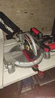 Side angle showing the Craftsman miter saw on a white surface with dust bag visible