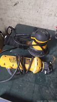 Two corded DeWalt power tools side by side on a tabletop: DW423 random orbit sander and DW660 cutout tool drill.