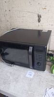 Photo of the black Black and Decker microwave on a white surface.