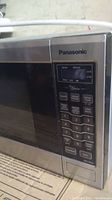 Close-up of Panasonic microwave control panel showing sensor and defrost options, numeric keypad, and start button