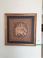 Framed square 3D wall art depicting a horseman on a horse in metallic embossed design surrounded by ornate patterns and mounted in a gold frame.