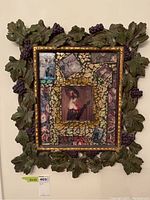 Full view of the framed artwork showing mosaic and grape leaf frame