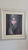 Framed original art on board showing a portrait of a woman with jewelry and long hair, front view.