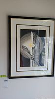 Full view of the framed abstract print hanging on a wall.