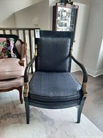 Front view of armchair showing the upholstered seat and back with visible wear on fabric and frame.