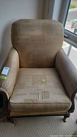 Front full view of the beige patterned Lillian August armchair showing condition, cushion, and design