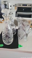 Photo showing the 9-inch glass jug, crystal decanter with stopper, and glass decanter with silver details