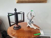 Photo of the wood sectional photo frame with four glass panels and rounded wooden base alongside the Nao ballerina figurine on a wooden table