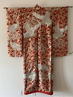 Front view of kimono displayed on metal rod against wall