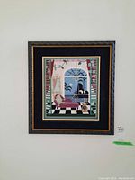 Framed needlepoint art of chaise lounge scene with potted plants and trees outside window