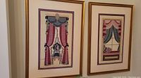Photo showing both framed needlepoint artworks side by side on a wall