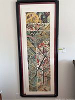 Full view of the framed abstract print demonstrating its tall rectangular shape and the large black frame with red inner border.