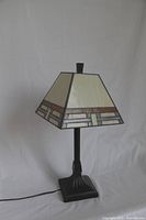 Full view of angular Tiffany-style table lamp with bronze mission-style base and stained glass shade.