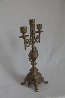 Full view of the three-arm solid brass candelabra showing its general shape and structure.