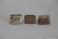 Front view of three vintage phonograph needle tins: two Songster and one Brilliantone.