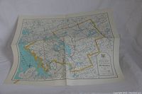 Full view of folded paper map of Muskoka showing roads, lakes, and yellow boundary outline