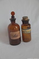Both amber glass apothecary jars shown side by side on white background