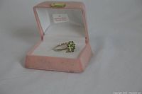 Ring angle showing peridot stones and sterling silver band in pink velvet box