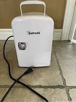Closed Astro AI white mini fridge front view showing handle and power cord