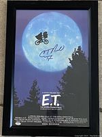 Front view of the framed 11x17 E.T. movie poster showing the bicycle flying across the full moon, signed by C. Thomas Howell.