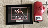 Frontal view of framed Rocky photo and Everlast glove on tiled floor
