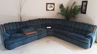 Full view of the blue sectional sofa with wood trim in a living room corner