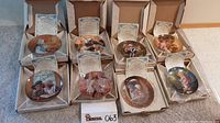 Eight Days Gone By collectible plates displayed in open boxes showing the certificate of authenticity for each plate.