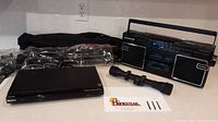 Photo showing all items together: Sony DVD player, Magnavox stereo, Sturm Ruger rifle scope, Precision Design tripod in case