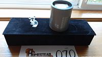 Swarovski crystal koala figurine along with original cylindrical box and black velvet display box on a surface